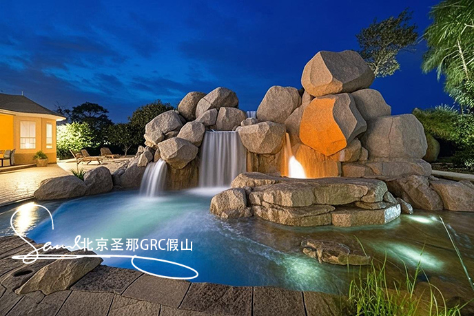 jimeng-2025-06-08-880-這是一處富有特色的水泥塑石景觀場景，是用粗糙的石頭制作，能有明顯的凸凹。水流從上層緩緩流下，落入下層的石池中。背景干凈，沒有其他建筑，只有噴泉本身，中遠景。....jpeg